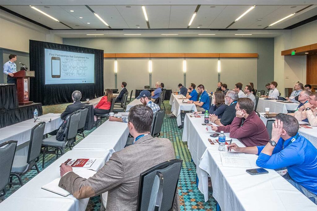 event attendees watching a speaker's presentation