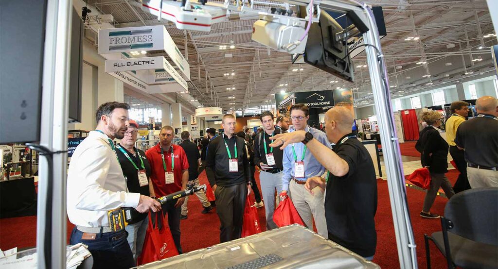 attendees listening to show floor presentation